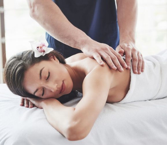 beautiful-woman-lying-on-massage-table-in-spa-PA3ZZD3-1.jpg